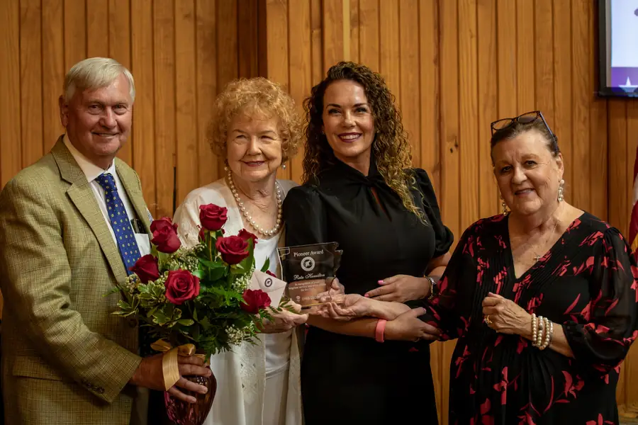 Party leadership presenting an award and roses to an honoree during the Legacy of Liberty dinner