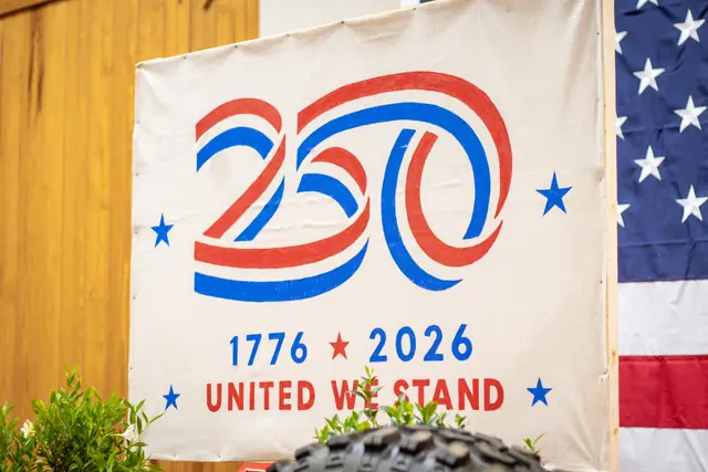 The 1776–2026 "United We Stand" banner behind the head table