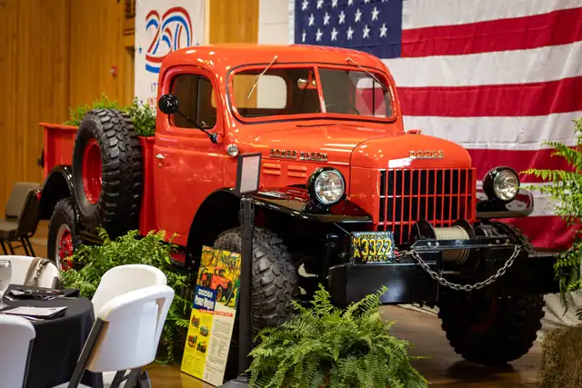 A vintage red Dodge Power Wagon beneath a full-wall American flag in the hall at the Legacy of Liberty dinner